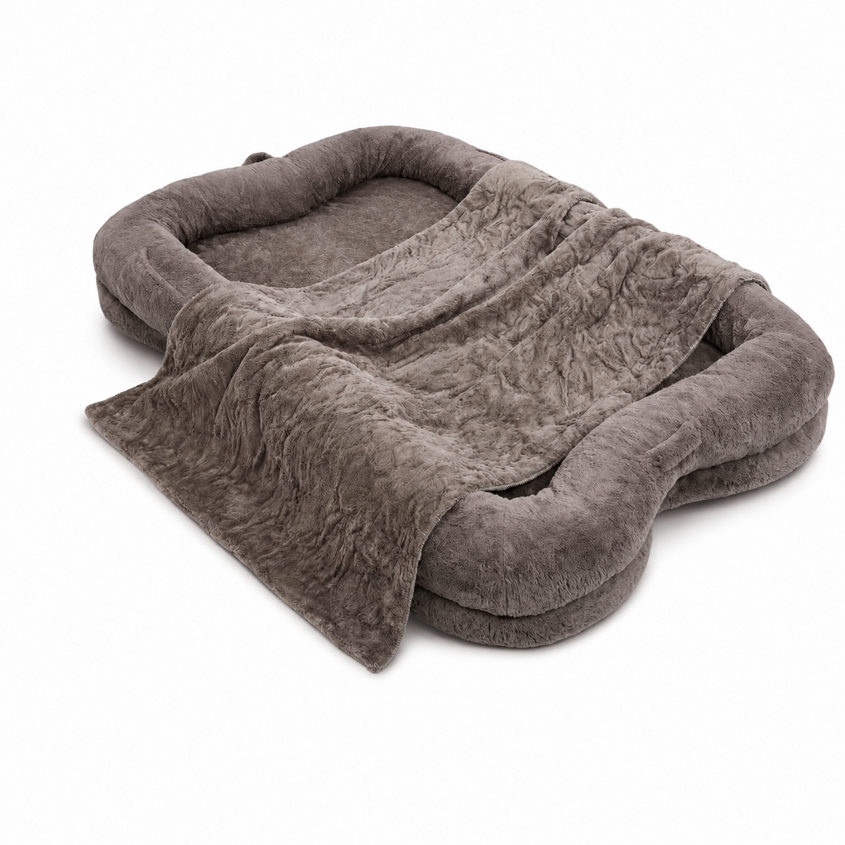 A plush, rounded rectangular pet bed in a warm taupe-brown color, styled with a matching textured throw blanket draped over the front, set against a plain white background.